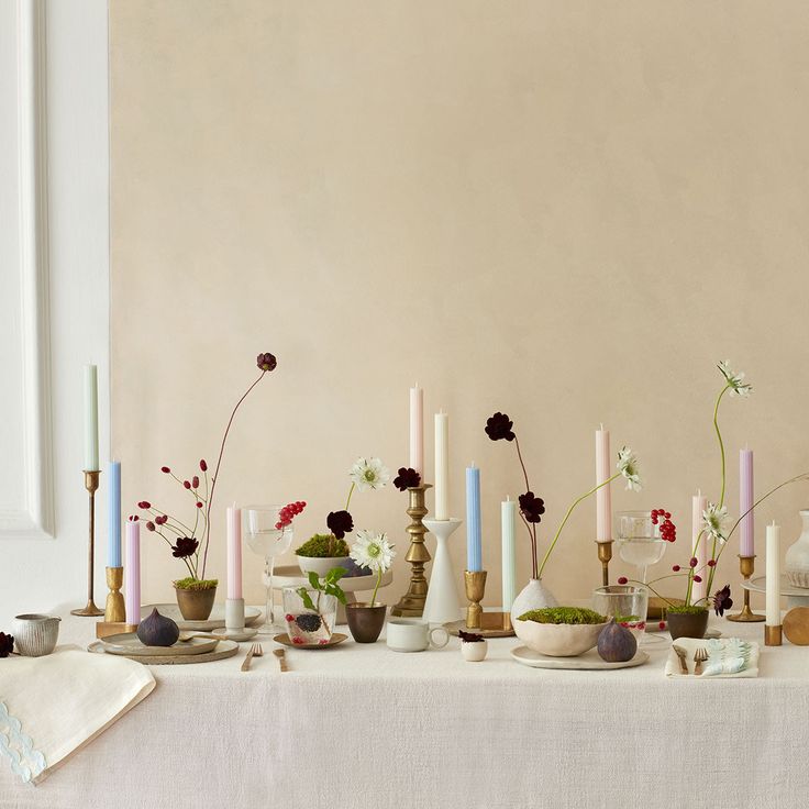 a table topped with lots of vases filled with different types of flowers and plants