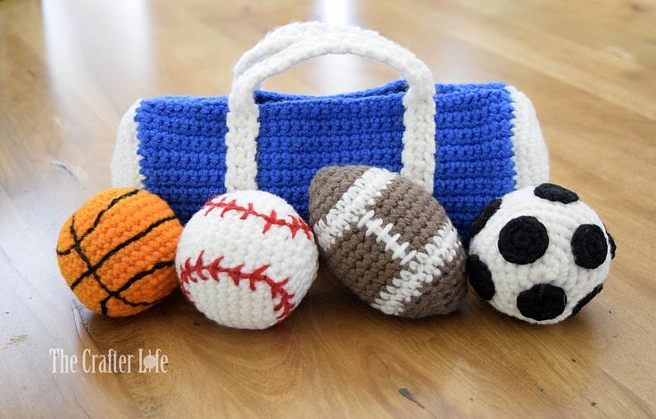 three crocheted sports balls sitting next to a purse