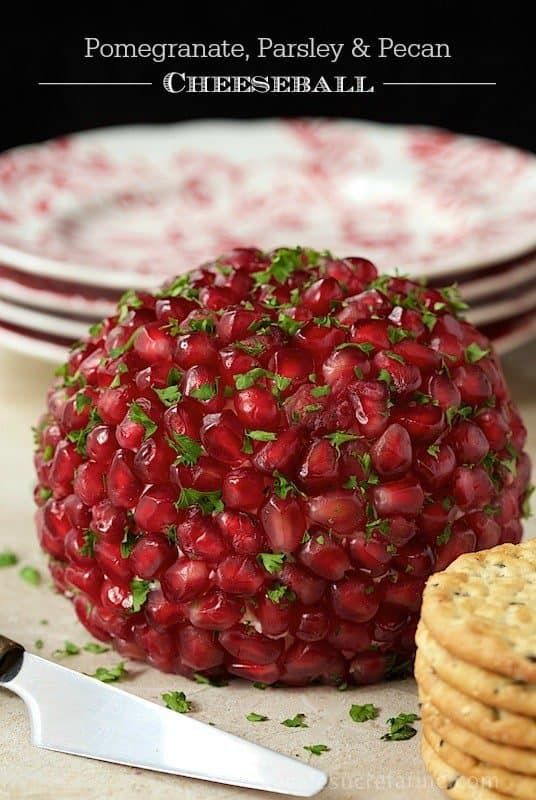 pomegranate, parsley and pecan cheeseball on a plate with crackers