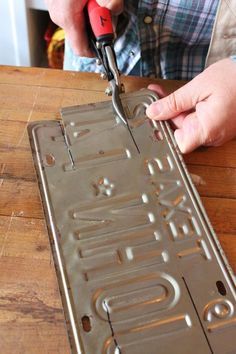 a person using a pair of pliers to cut out letters on a cookie sheet