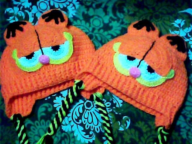 two orange knitted hats with eyes on them