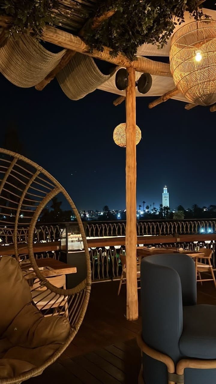 an outdoor seating area with hanging chairs and lights