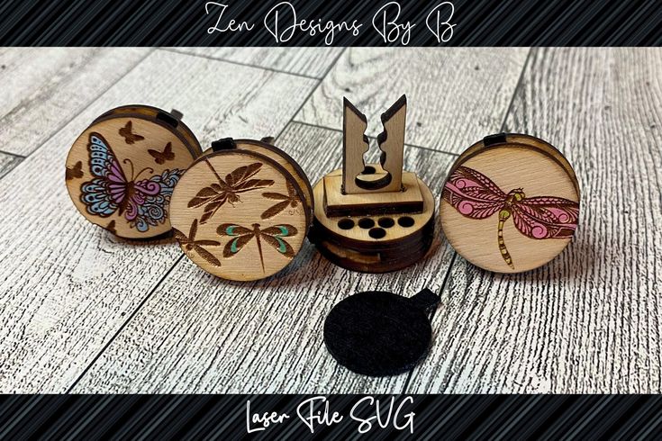 three wooden cufflinks with dragonflies on them and a black piece of string