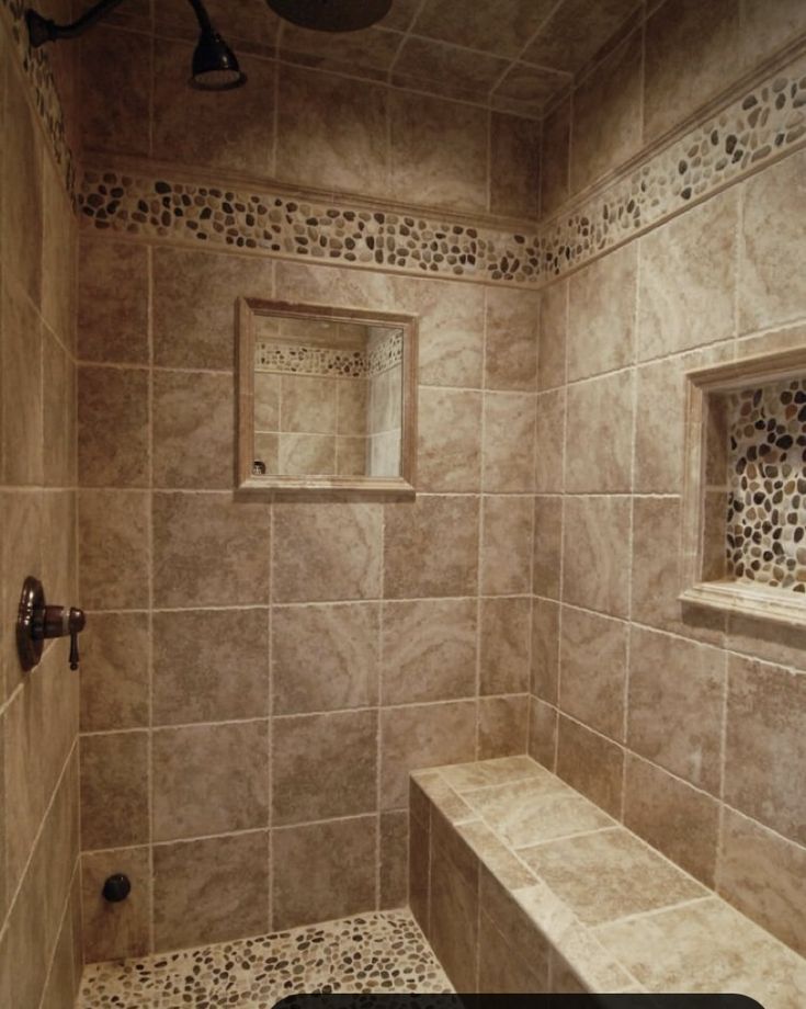 a walk in shower sitting next to a window and tiled walls with decorative tiling