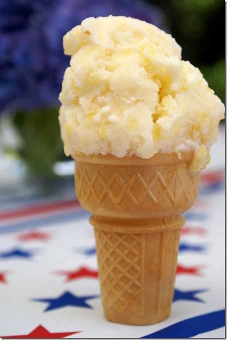 a scoop of ice cream sitting on top of an american flag tablecloth with flowers in the background