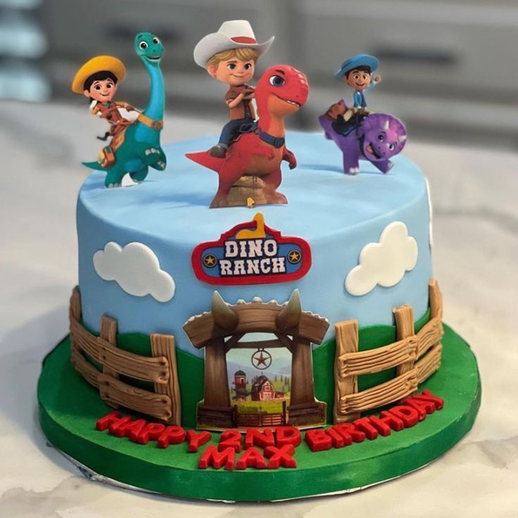 a birthday cake with toy dinosaurs on top and the name dino ranch written on it