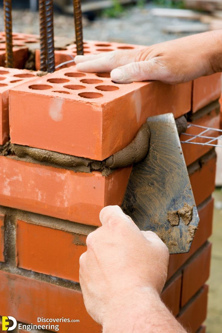 a man is placing bricks on top of a brick wall