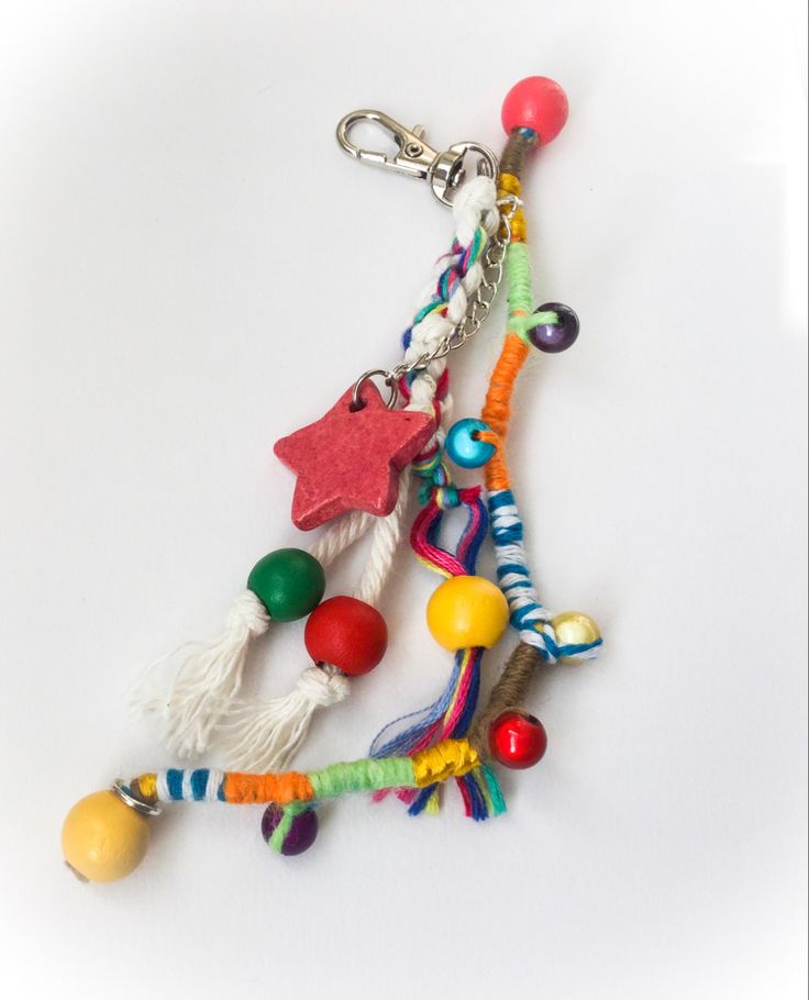 an assortment of colorful beads and charms on a white surface with a keychain