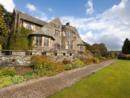 a large stone house sitting on top of a lush green field