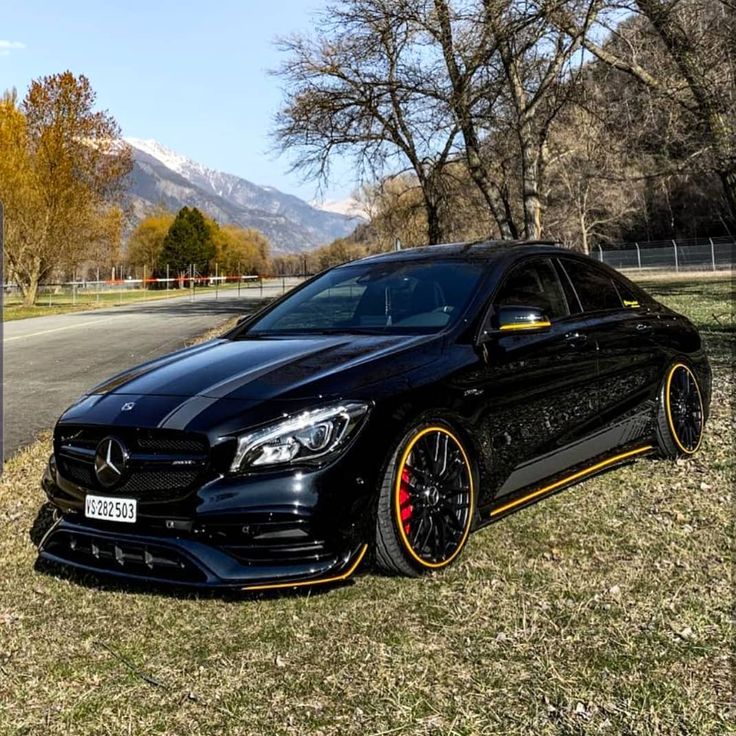 a black mercedes cla parked in the grass