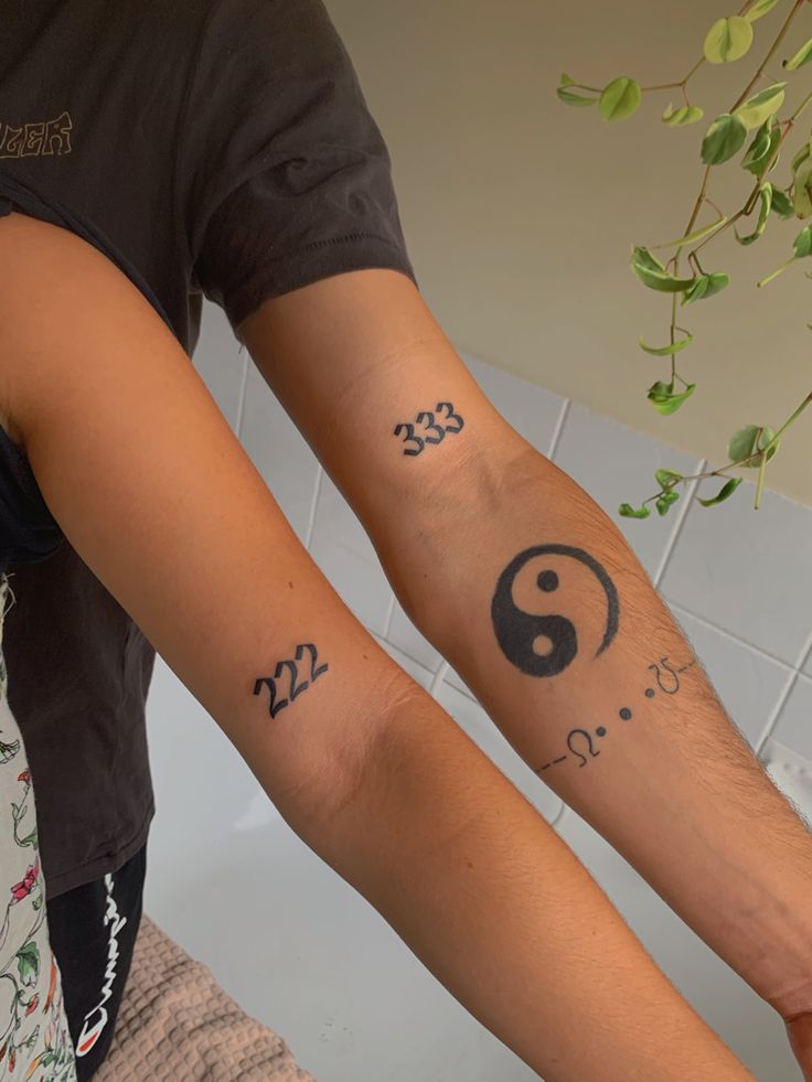 two people with matching tattoos on their arms