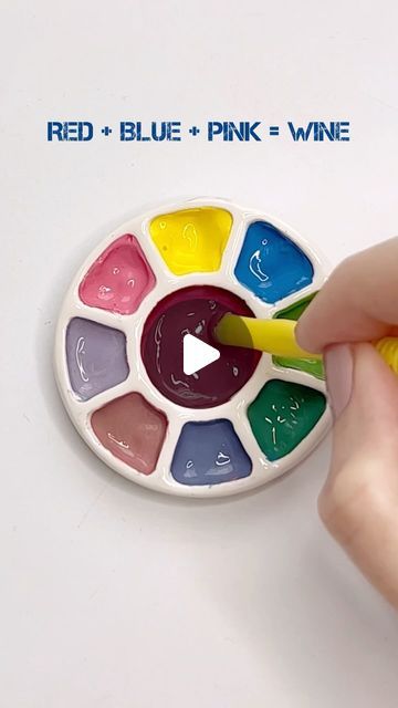 a person is holding a paintbrush in their hand and painting the inside of a colorful wheel