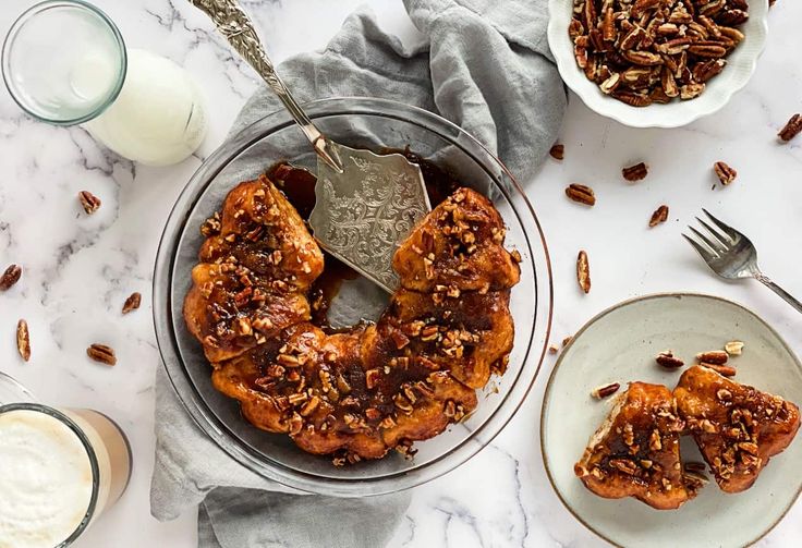 two plates with pecans on them next to some milk