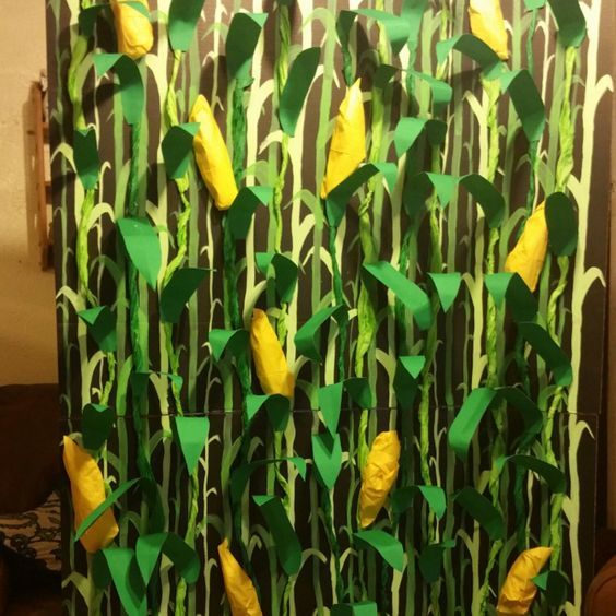 a green and yellow wall with paper cut out of it's leaves that have the letter e on them