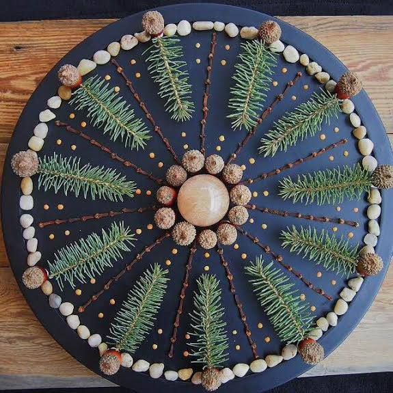 a blue plate topped with pine cones and beads