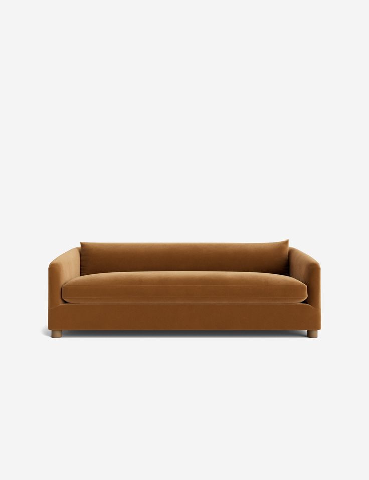 a brown couch sitting on top of a white floor next to a gray wall with a black frame