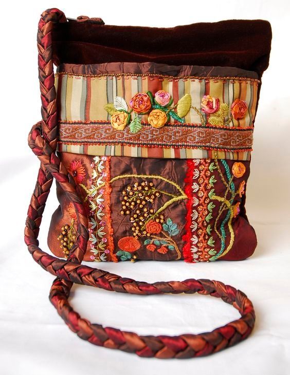 a handbag is decorated with flowers and braided leather straps, along with a brown cord