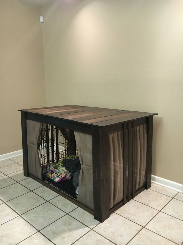 an empty room with a dog cage in the middle and tiled flooring on the other side