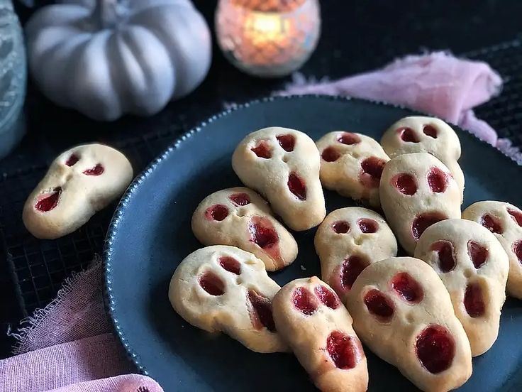 a plate full of heart shaped cookies on a table next to candles and pumpkins