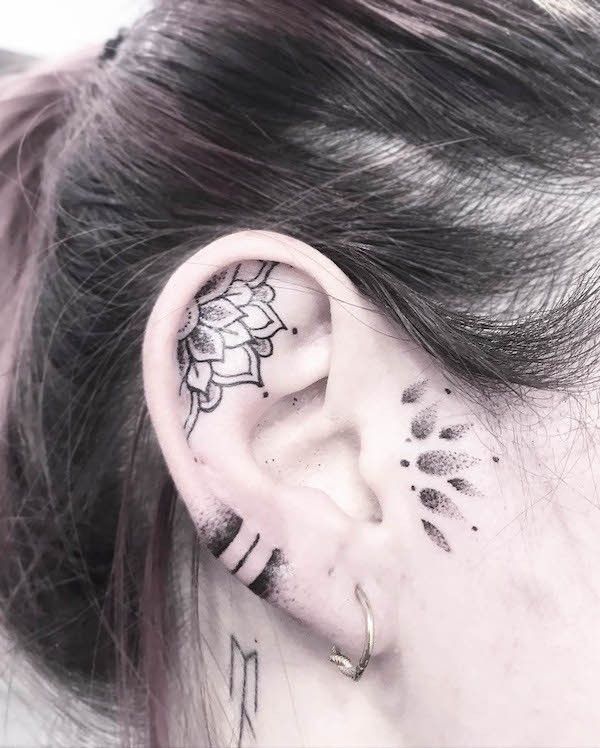 a woman's ear with tattoos on it