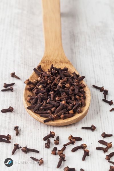 a wooden spoon filled with chocolate flakes on top of a table