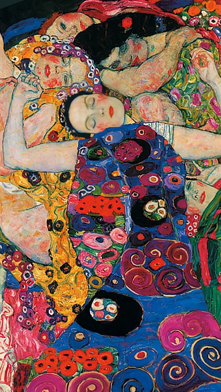 two women are laying on a colorful blanket