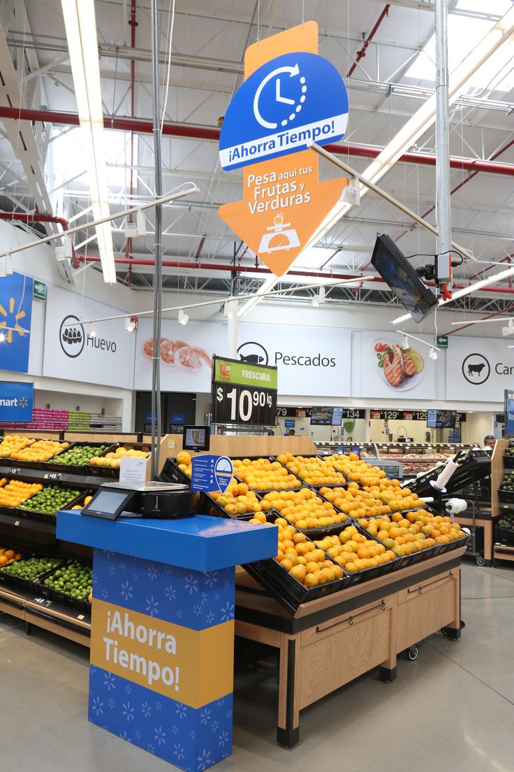 the produce section of a grocery store with oranges and bananas on display for sale