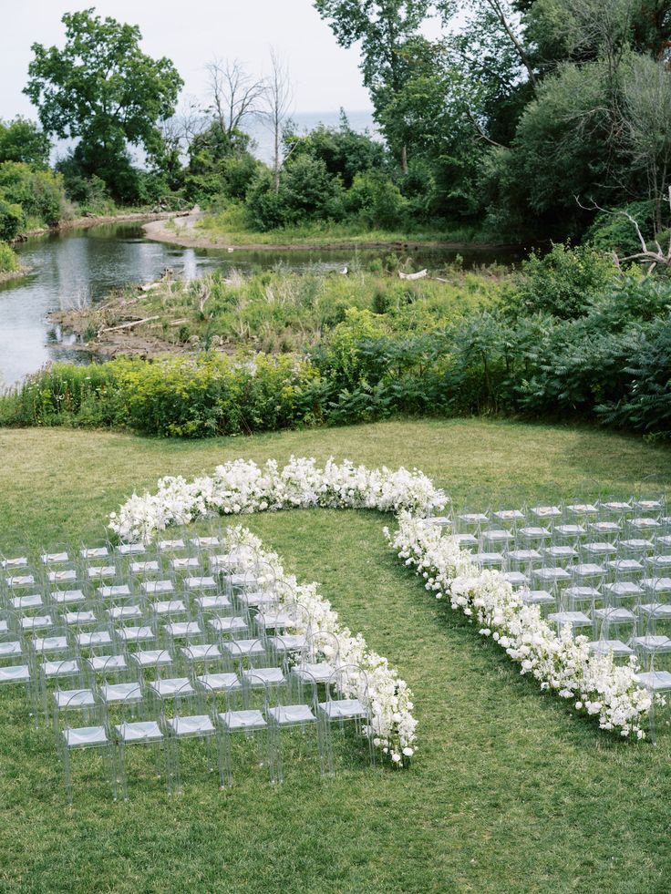 an outdoor ceremony setup with white flowers and greenery in the shape of a heart