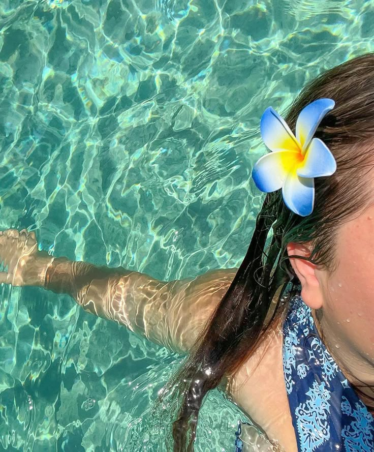 a woman with a flower in her hair swimming