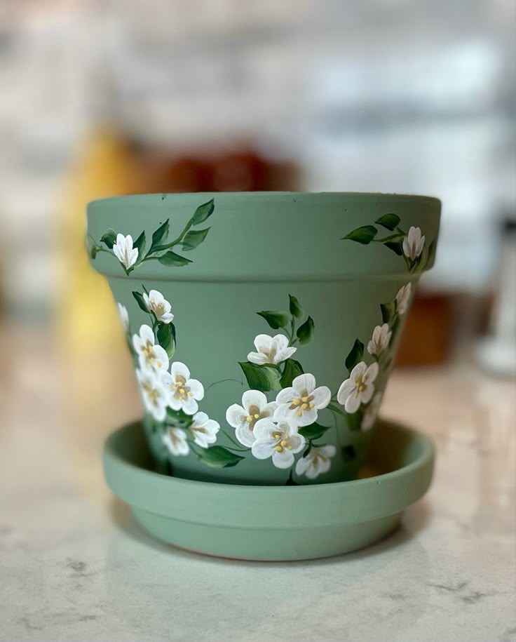 a green bowl with white flowers painted on it