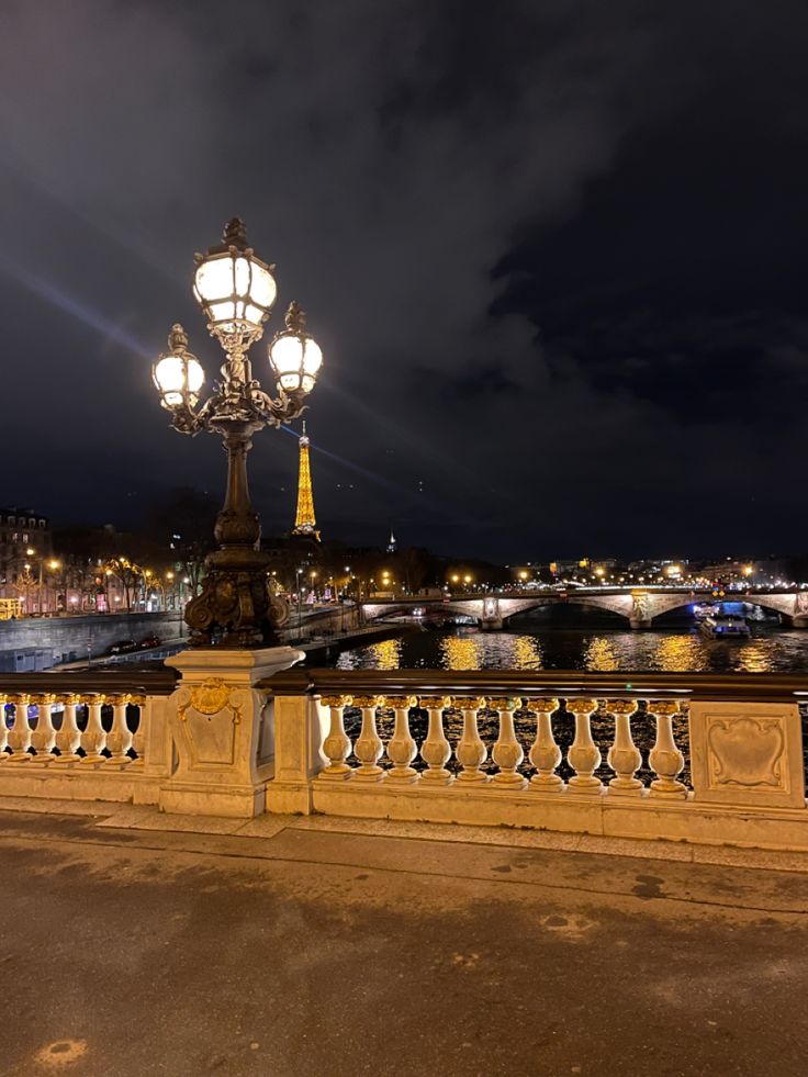 a street light sitting on the side of a bridge next to a body of water