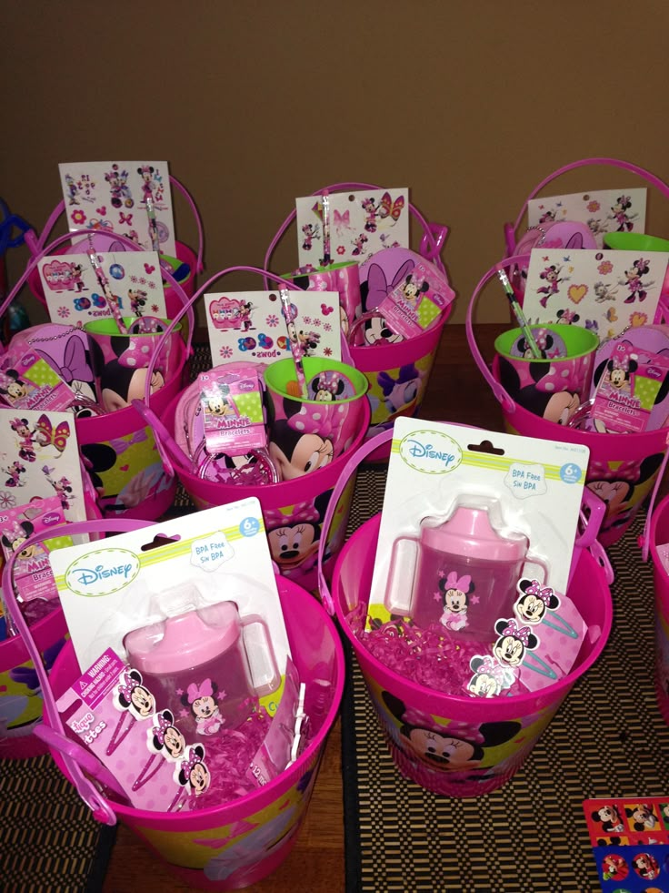 several pink baskets filled with toys on top of a table