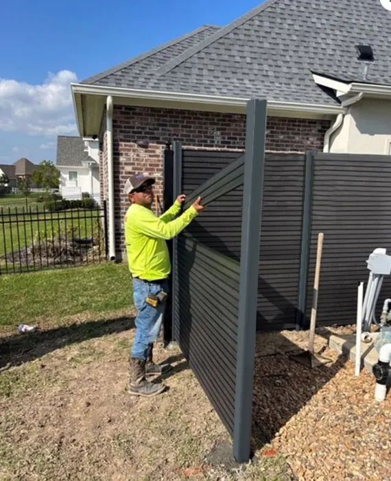 a man standing next to a fence in front of a house