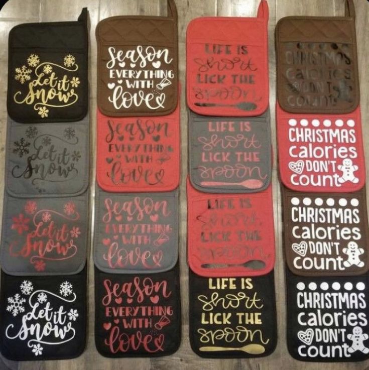 six oven mitts with christmas sayings on them in different colors and designs, all lined up against a wood floor