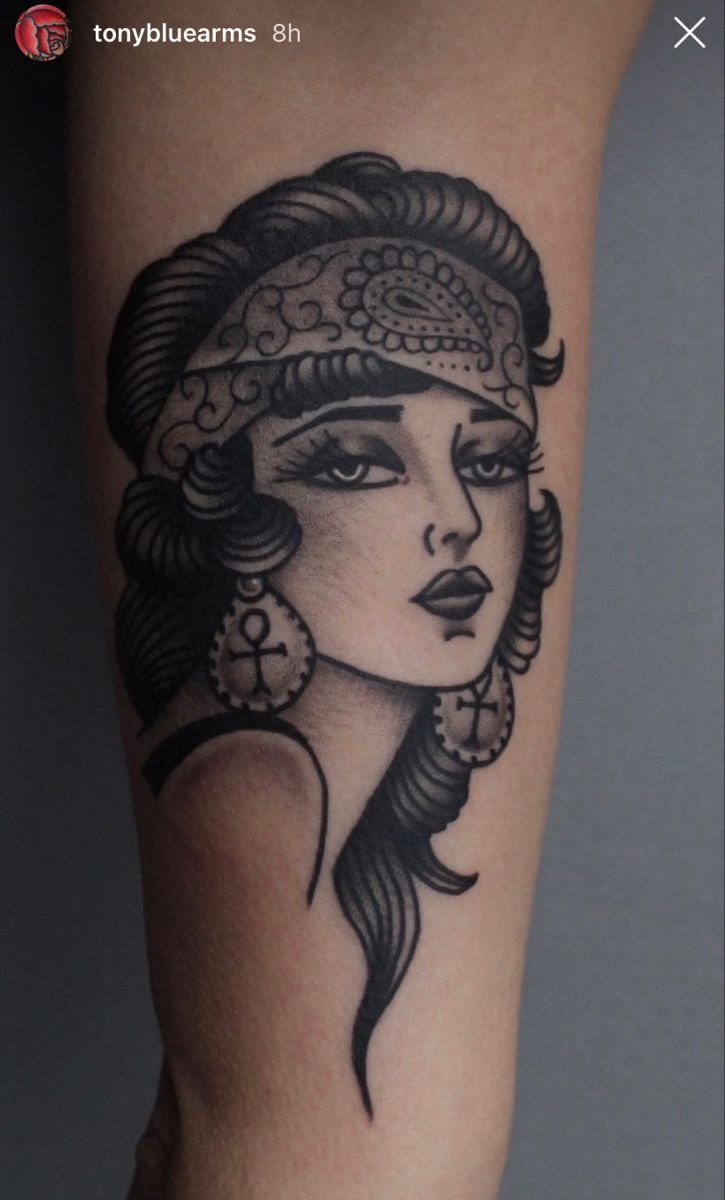 a woman's arm with a tattoo on it, and an ornate headpiece