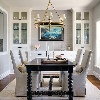 a dining room table with chairs and a chandelier hanging from it's ceiling