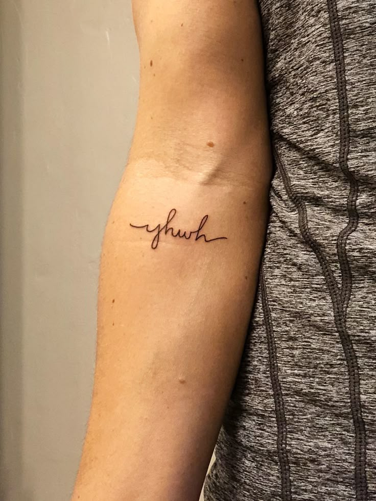 a man with a tattoo on his arm that says, faith in cursive writing