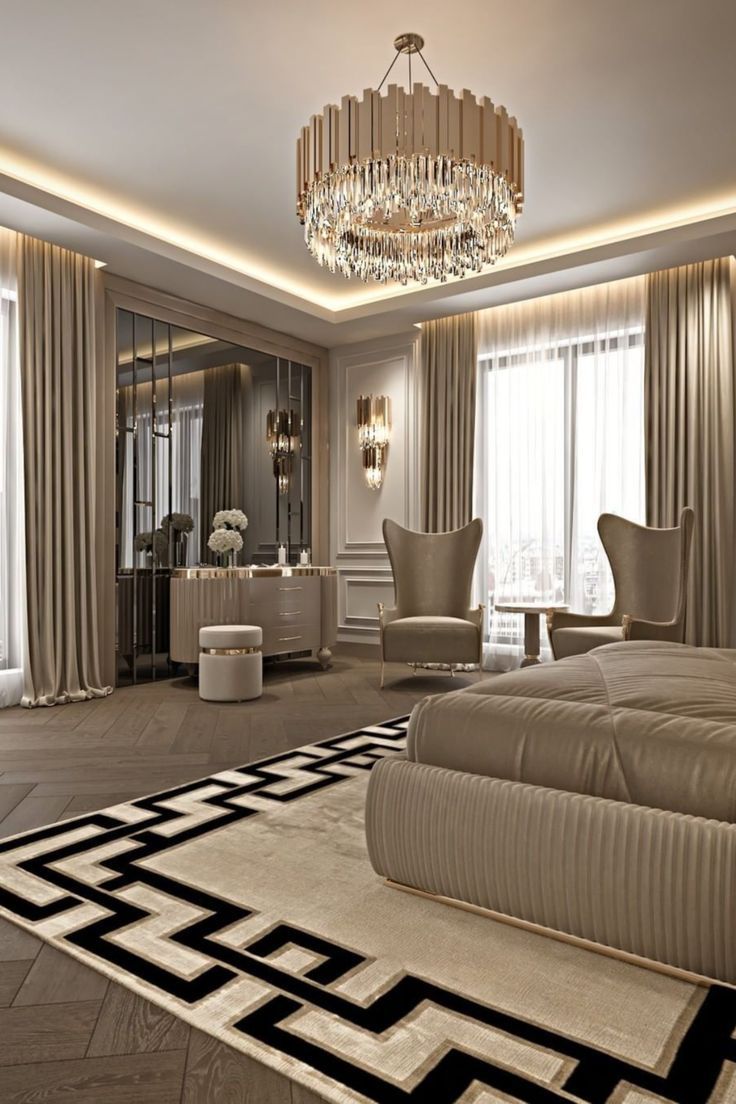 an elegant bedroom with chandelier, chair and large rug on the floor in front of two windows