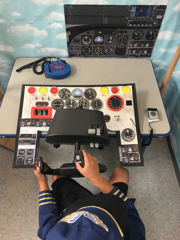 a man sitting in front of a control panel