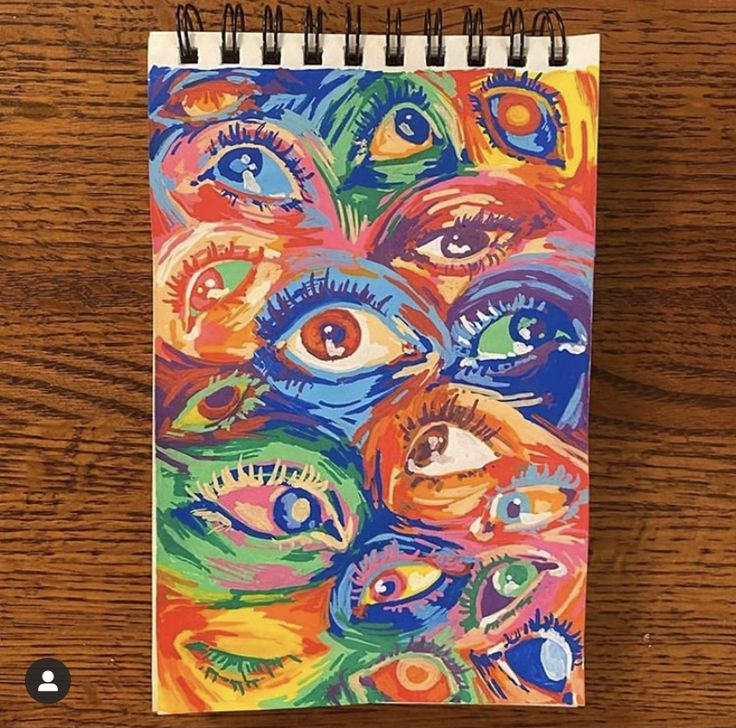 a spiral notebook with an eye painting on it