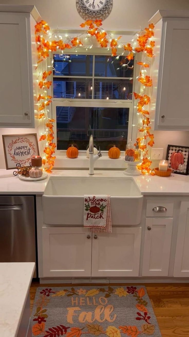 a kitchen decorated for fall with lights and decorations