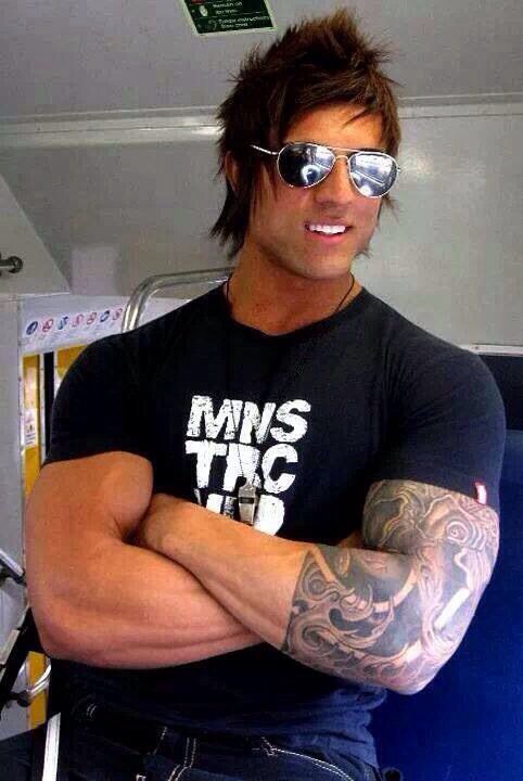 a man with tattoos and sunglasses on his arm posing for a photo in the bus