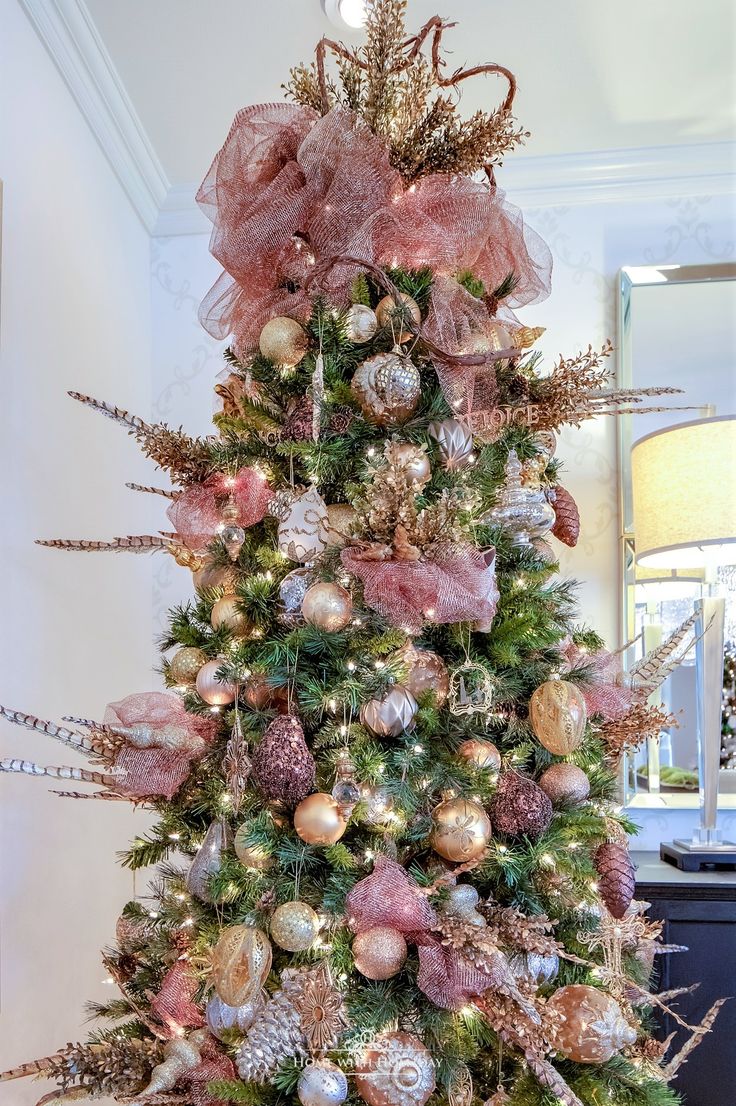 a christmas tree decorated with pink and gold ornaments