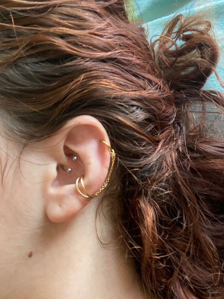 a close up of a person's ear with an earring in the shape of a circle