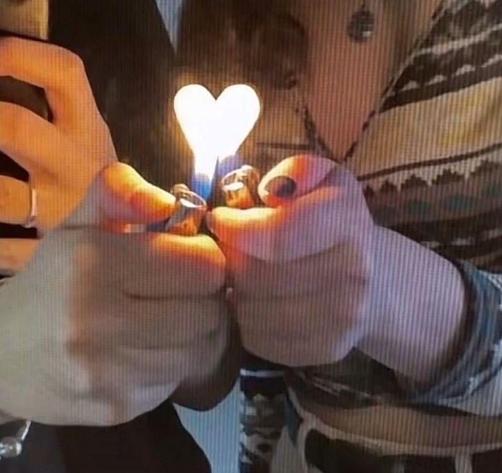 two people holding up their cell phones to show the light bulb on them's fingers