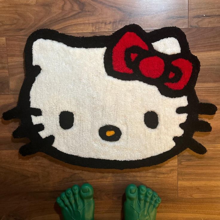 a hello kitty rug on the floor with green feet