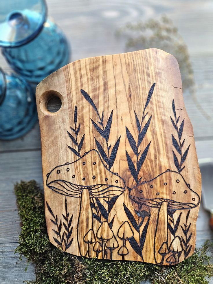 a wooden cutting board sitting on top of a table next to vases and plants