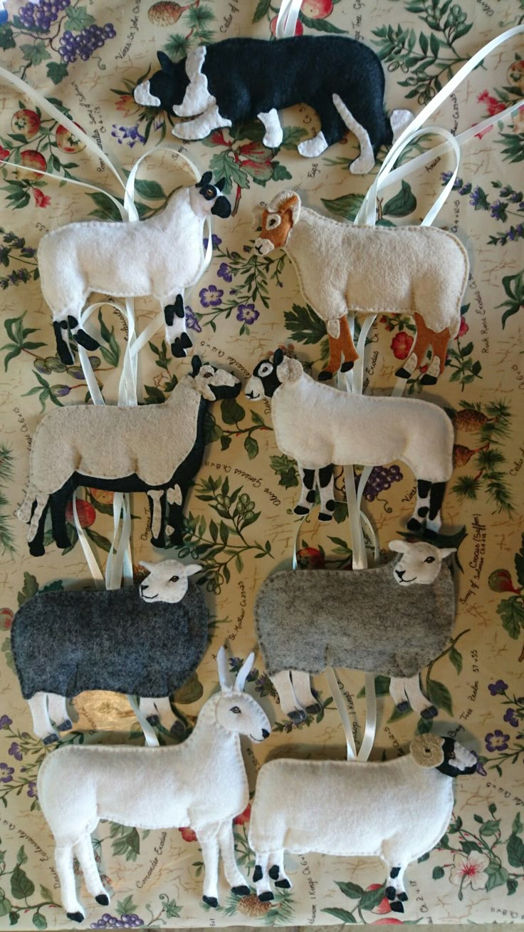 several sheep and lambs are arranged on a floral wallpapered area with flowers