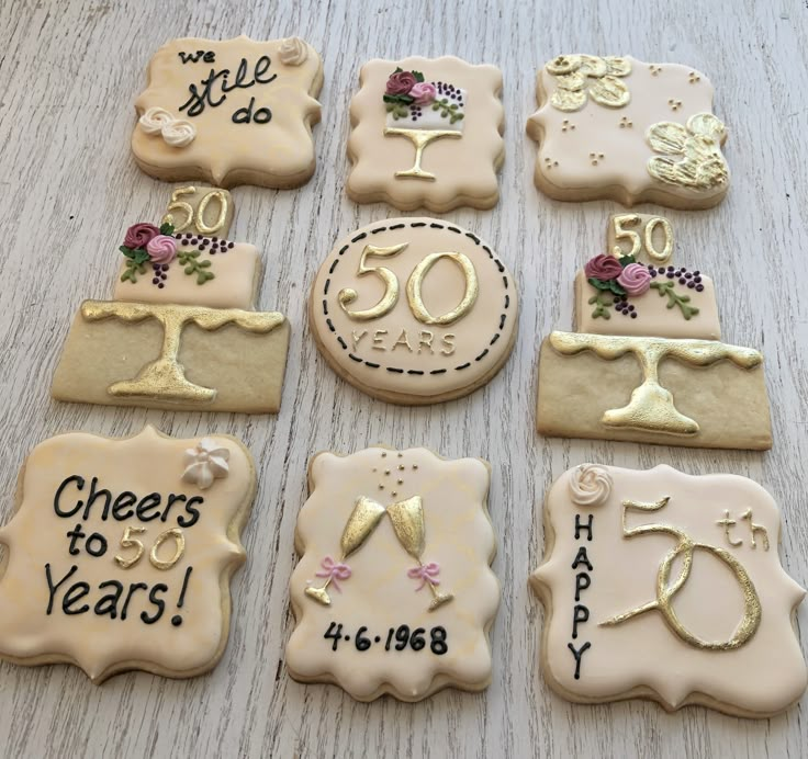 decorated cookies are arranged in the shape of 50th birthday cakes and cake toppers for someone's 50 year old