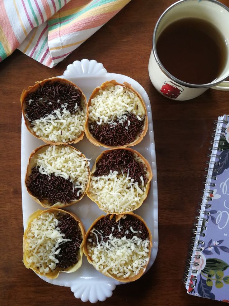 several pastries on a plate next to a cup of coffee